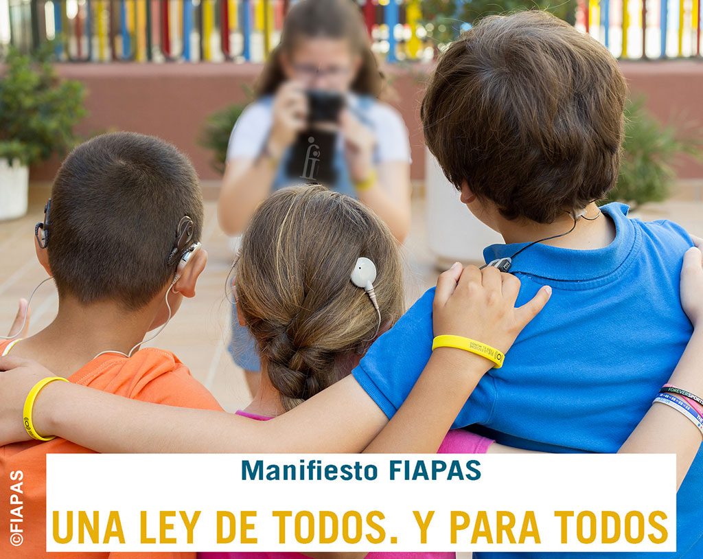 tres niños con prótesis auditivas haciéndose una foto