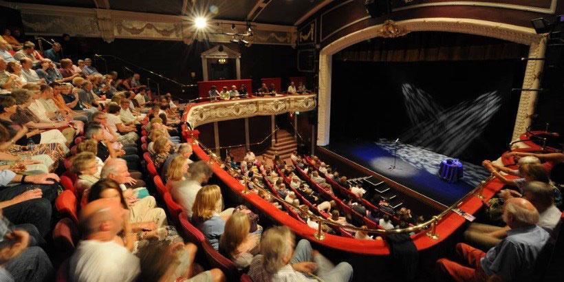 Interior de un teatro lleno de gente