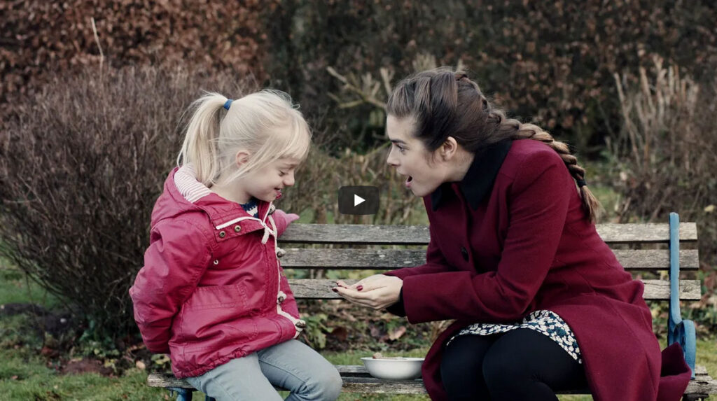Mujer enseñando algo en las manos a una niña sorda