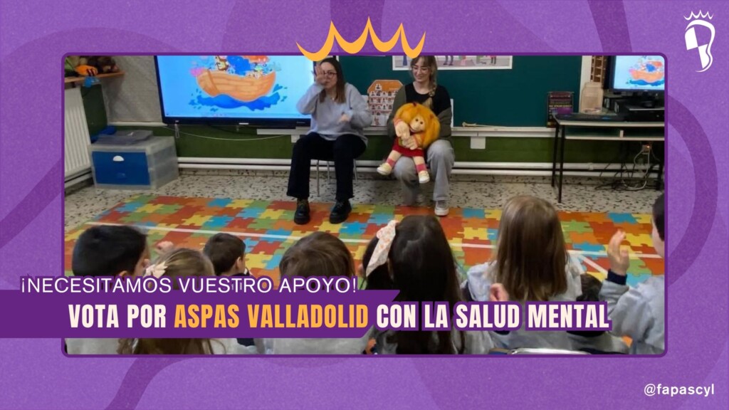 Grupo de niños sentados de espaldas en el suelo mirando a dos monitoras; una de ellas utiliza una marioneta mientras ambas realizan signos de comunicación.